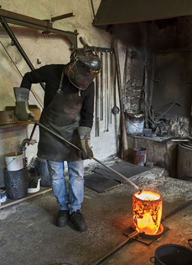 Poche de bronze en fusion. L'opérateur retire le laitier (scories) (1). © Région Bourgogne-Franche-Comté, Inventaire du patrimoine