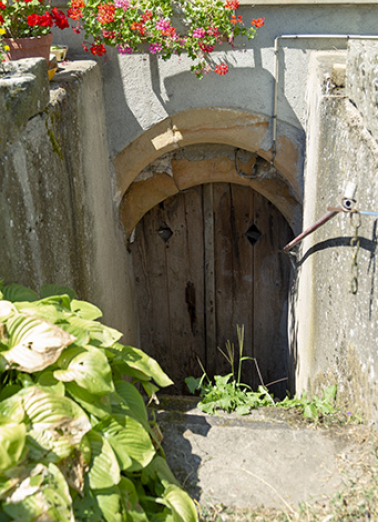 Entrée de cellier à arc en plein cintre, à ressauts formé de deux rouleaux. (4 rue du Château.) © Région Bourgogne-Franche-Comté, Inventaire du patrimoine Entrée de cellier à arc en plein cintre, à ressauts formé de deux rouleaux. (4 rue du Château.) © Région Bourgogne-Franche-Comté, Inventaire du patrimoine
