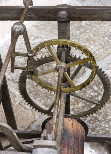 Corps avant droit (partage du temps) : échappement à chevilles, vu en plongée. La roue d'échappement (en laiton) est munie de chevilles qui interagissent avec l'ancre à gauche. © Région Bourgogne-Franche-Comté, Inventaire du patrimoine Corps avant droit (partage du temps) : échappement à chevilles, vu en plongée. La roue d'échappement (en laiton) est munie de chevilles qui interagissent avec l'ancre à gauche. © Région Bourgogne-Franche-Comté, Inventaire du patrimoine