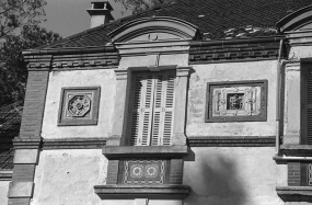 Détail de la façade sud : panneaux de céramique encadrant une baie de l'étage en surcroît (provenance indéterminée). © Région Bourgogne-Franche-Comté, Inventaire du patrimoine