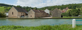 Au premier plan : des corps de ferme en bordure du canal, à l'arrière-plan : le château de Courcelles-lès-Montbard. © Région Bourgogne-Franche-Comté, Inventaire du patrimoine
