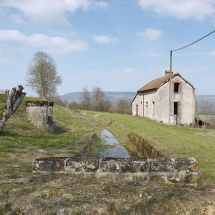 Vue d'ensemble de la maison de garde avec au centre la rigole et à gauche, le puits. On aperçoit la borne à l'extrême gauche. © Région Bourgogne-Franche-Comté, Inventaire du patrimoine