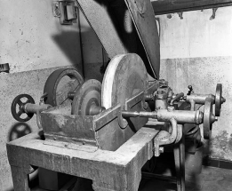 Vue d'ensemble de la partie supérieure, capot ouvert.Prise entre pointe et contre-pointe, la meule métallique frotte contre la meule abrasive. © Région Bourgogne-Franche-Comté, Inventaire du patrimoine