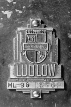 Plaque signalétique et logotype de la société Ludlow. La plaque est fixée à l'arrière du boîtier des instruments de mesure. © Région Bourgogne-Franche-Comté, Inventaire du patrimoine