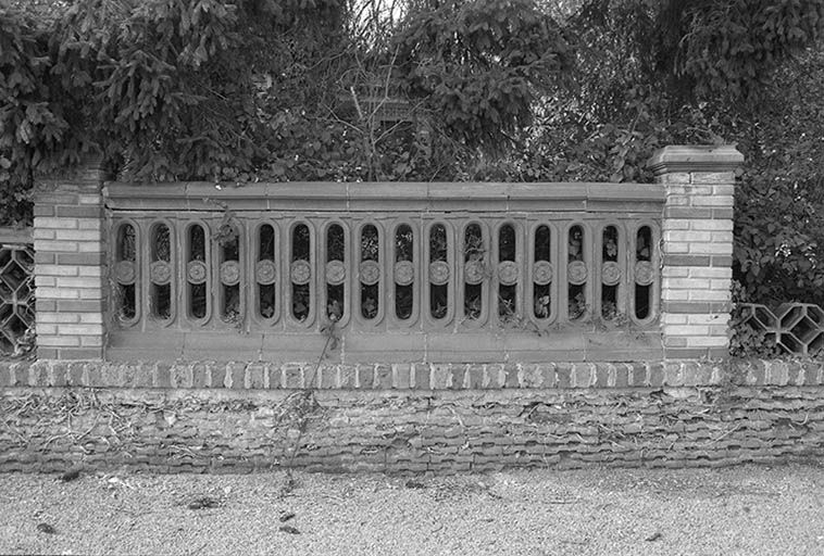 Mur de clôture constitué d'éléments en céramique produits par les établissements Perrusson & Desfontaines (73-74 route du Canal). © Frédéric Pillet / Région Bourgogne-Franche-Comté, Inventaire du patrimoine - 1999