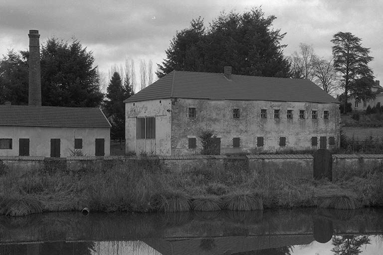 A gauche, remise, garage, dépôt de terre et cheminée ; à droite bâtiment comprenant un four (détruit) et des ateliers de production (tours...) de l'usine "du Bas", vus depuis l'ouest. © Frédéric Pillet / Région Bourgogne-Franche-Comté, Inventaire du patrimoine - 1999