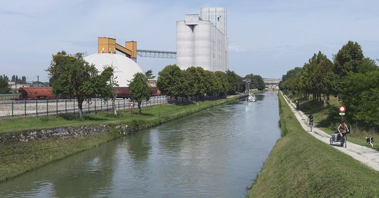 A Brienon-sur-Armançon, vue d'ensemble des silos avec accès par pont roulant au canal. A l'extrême-gauche, les voies SNCF. © Thierry Kuntz / Région Bourgogne-Franche-Comté, Inventaire du patrimoine - 2011