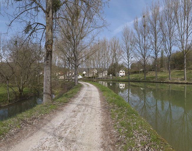 Passage du canal dans la vallée de l'Ouche : l'Ouche, le chemin de halage, au fond : le site d'écluse 25 et le canal avec un alignement d'arbres de chaque côté. © Thierry Kuntz / Région Bourgogne-Franche-Comté, Inventaire du patrimoine - 2012