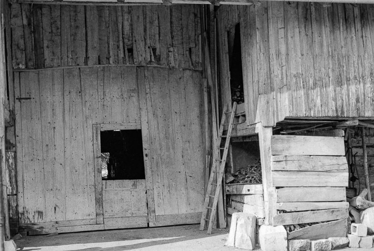 Ferme cadastrée 1962 E 174-175 : porte de grange et galerie en bois fermée servant de bûcher. © Gilbert Poinsot / Région Bourgogne-Franche-Comté, Inventaire du patrimoine - 1975