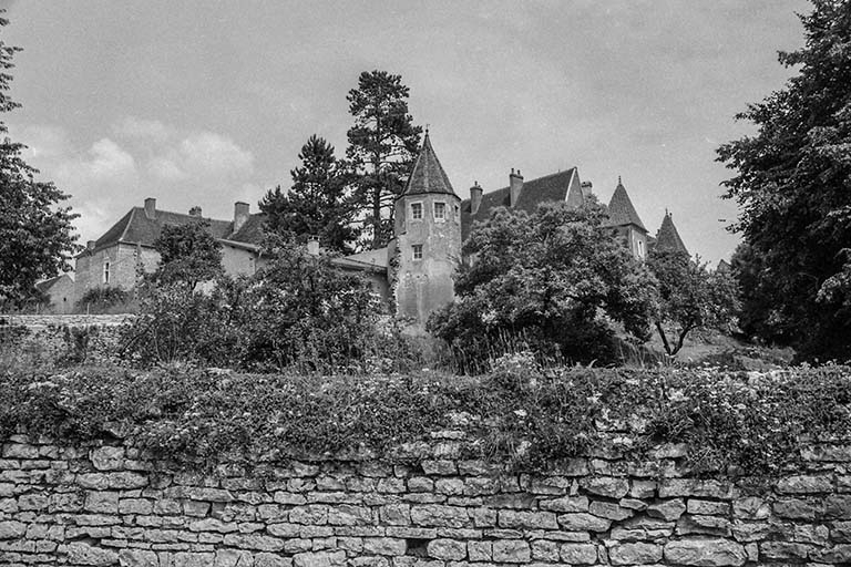 Rempart et tourelle située sur le tracé sud des fortifications (transformée en habitation). En arrière-plan, les demeures situées rue des Châteaux. © Bernard Lardière / Région Bourgogne-Franche-Comté, Inventaire du patrimoine - 1981
