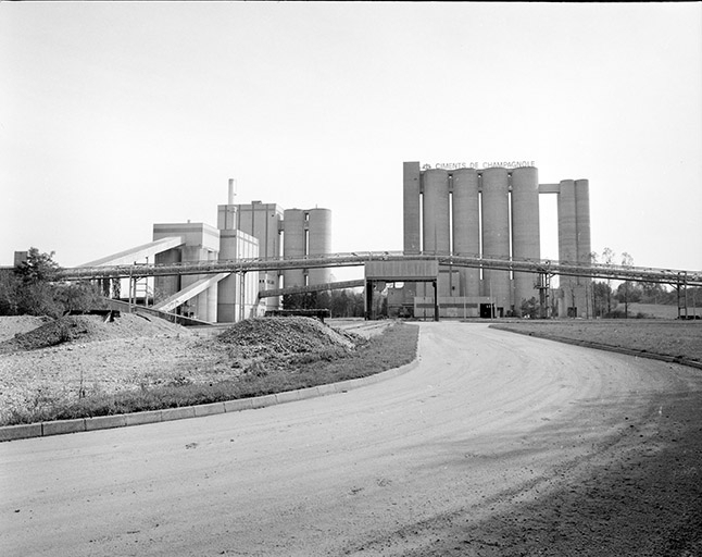Vue d'ensemble depuis le nord-ouest : transporteur à bande, atelier de fabrication à gauche, silos et conditionnement à droite. © Yves Sancey / Région Bourgogne-Franche-Comté, Inventaire du patrimoine - 1988