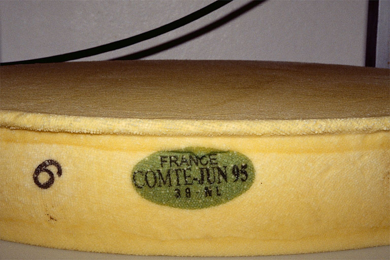 Fromage démoulé, après pressage. La plaque de caséine verte identifie la fromagerie d'origine du comté et mentionne sa date de fabrication. © Jérôme Mongreville / Région Bourgogne-Franche-Comté, Inventaire du patrimoine - 1995