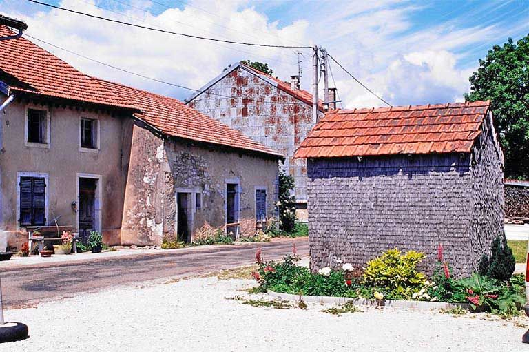 Vue de trois quarts de la façade antérieure et, au premier plan, la resserre. © Yves Sancey / Région Bourgogne-Franche-Comté, Inventaire du patrimoine - 1999 Vue de trois quarts de la façade antérieure et, au premier plan, la resserre. © Yves Sancey / Région Bourgogne-Franche-Comté, Inventaire du patrimoine - 1999