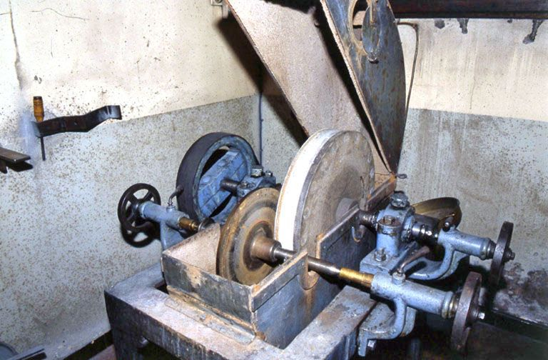 Vue d'ensemble de la partie supérieure, capot ouvert.Prise entre pointe et contre-pointe, la meule métallique frotte contre la meule abrasive. © Jérôme Mongreville / Région Bourgogne-Franche-Comté, Inventaire du patrimoine - 2001