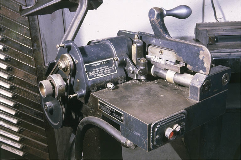 Détail : systèmes d'entraînement de la fraise et de fixation de la ligne-bloc. Une ligne-bloc est serrée dans la machoire. © Jérôme Mongreville / Région Bourgogne-Franche-Comté, Inventaire du patrimoine - 2001