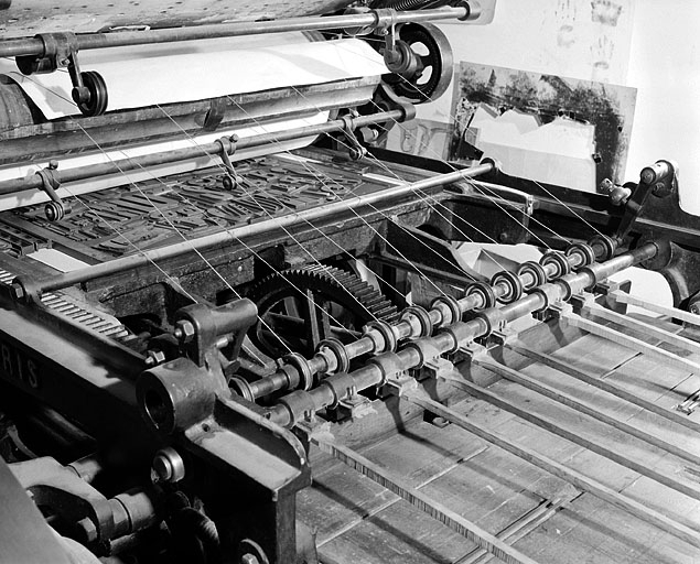 Partie arrière de la machine. Les fils permettent de soutenir la feuille qui sera déposée sur la table de réception, à droite, à l'aide du receveur mécanique à raquettes. © Jérôme Mongreville / Région Bourgogne-Franche-Comté, Inventaire du patrimoine - 2001