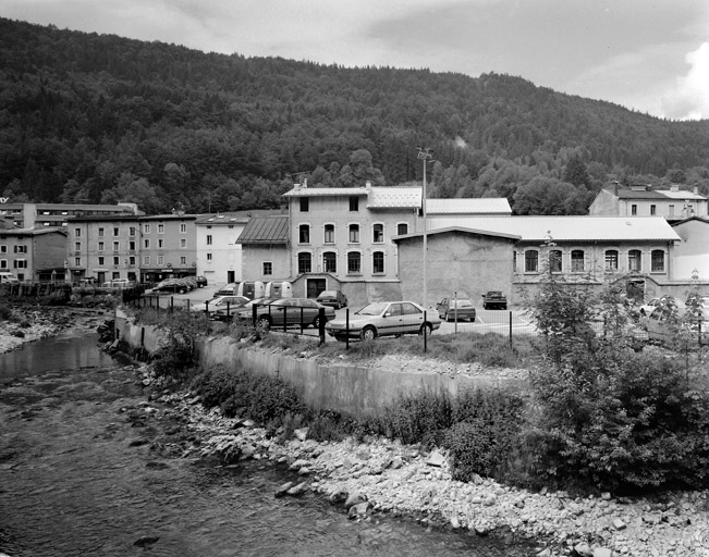 Le quartier de l'école du Haut, depuis la rive droite de la Bienne. L'école est vue de l'arrière. © Yves Sancey / Région Bourgogne-Franche-Comté, Inventaire du patrimoine - 2003 Le quartier de l'école du Haut, depuis la rive droite de la Bienne. L'école est vue de l'arrière. © Yves Sancey / Région Bourgogne-Franche-Comté, Inventaire du patrimoine - 2003