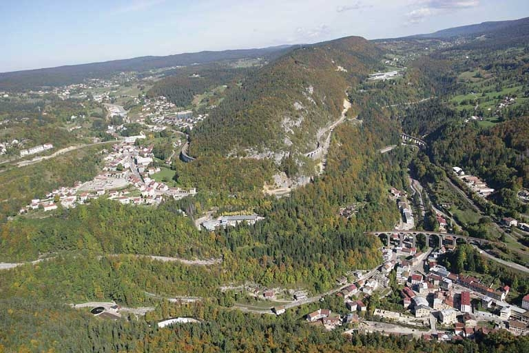 Vue aérienne du relief de la zone de Morbier - Morez, depuis le sud-ouest. À gauche, la ville de Morbier ; à droite, la vallée de l'Evalude, barrée au premier plan par le viaduc de Paul Séjourné. © Jean-Pierre Bévalot / Région Bourgogne-Franche-Comté, Inventaire du patrimoine - 2005
