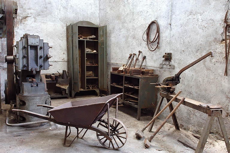 Angle ouest de la forge du Bas : martinet, armoire et casiers, brouette et cisaille manuelle. © Jérôme Mongreville / Région Bourgogne-Franche-Comté, Inventaire du patrimoine - 2005 Angle ouest de la forge du Bas : martinet, armoire et casiers, brouette et cisaille manuelle. © Jérôme Mongreville / Région Bourgogne-Franche-Comté, Inventaire du patrimoine - 2005