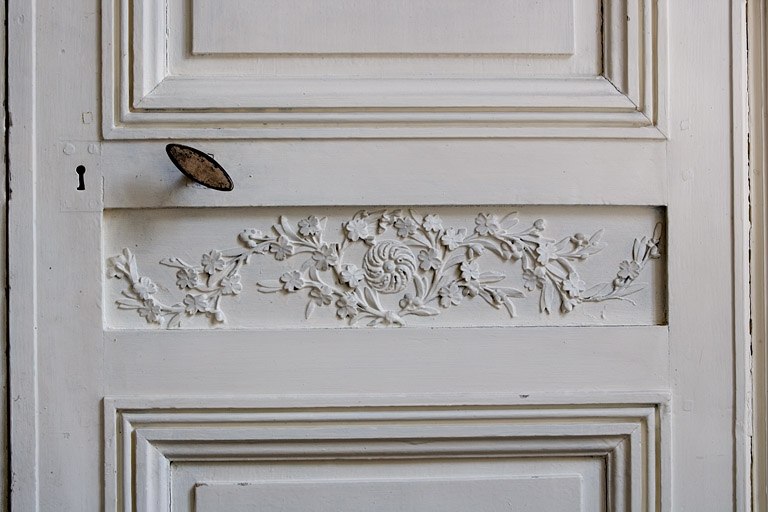 Intérieur, premier étage : détail du décor sculpté d'un panneau médian de la porte d'entrée de la bibliothèque. © Yves Sancey / Région Bourgogne-Franche-Comté, Inventaire du patrimoine - 2007