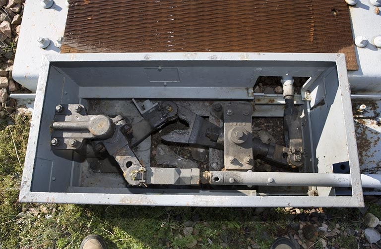 Système de renvoi d'angle. La tringle actionnant les aiguilles (en haut) est reliée à celle du levier de manoeuvre par une pièce métallique dite " pince de homard ". © Yves Sancey / Région Bourgogne-Franche-Comté, Inventaire du patrimoine - 2007