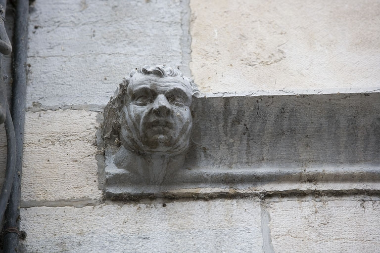 Façade sur rue : détail d'une tête d'homme à l'extrémité gauche du bandeau d'appui. © Yves Sancey / Région Bourgogne-Franche-Comté, Inventaire du patrimoine - 2009