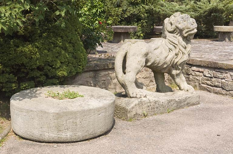 Meule et lion sculpté, déposés à l'extérieur de la boutique. © Jérôme Mongreville / Région Bourgogne-Franche-Comté, Inventaire du patrimoine - 2009