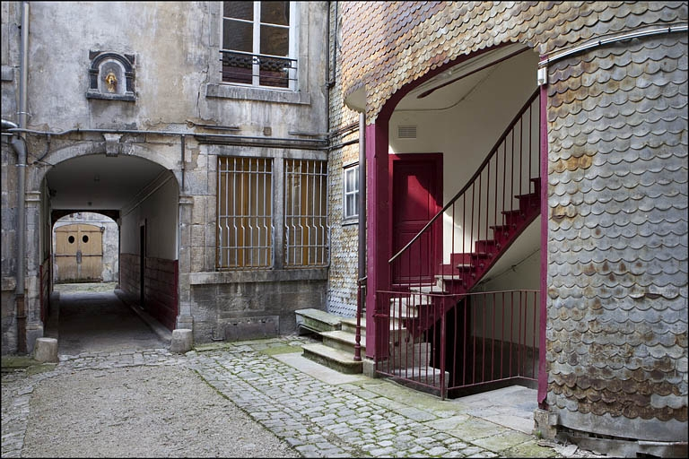 Détail du départ de l'escalier à cage ouverte et du deuxième passage cocher, depuis l'entrée de la première cour. © Yves Sancey / Région Bourgogne-Franche-Comté, Inventaire du patrimoine - 2010
