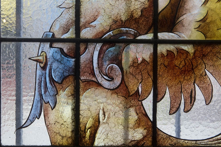 Intérieur, vitrail dans une fenêtre du rez-de-chaussée : détail rapproché de la cuirasse d'un dragon. © Yves Sancey / Région Bourgogne-Franche-Comté, Inventaire du patrimoine - 2010