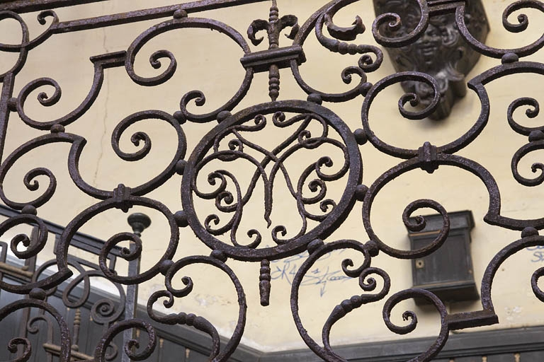 Première cour : détail de la ferronnerie de l'escalier à cage ouverte ornée d'un monogramme. © Yves Sancey / Région Bourgogne-Franche-Comté, Inventaire du patrimoine - 2011