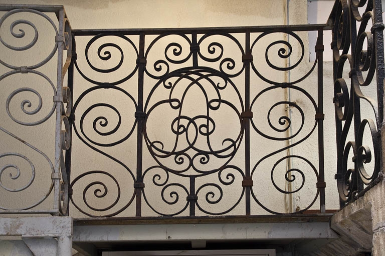 Première cour, escalier à cage ouverte : détail d'un panneau de la rampe en fer forgé avec un monogramme. © Yves Sancey / Région Bourgogne-Franche-Comté, Inventaire du patrimoine - 2011