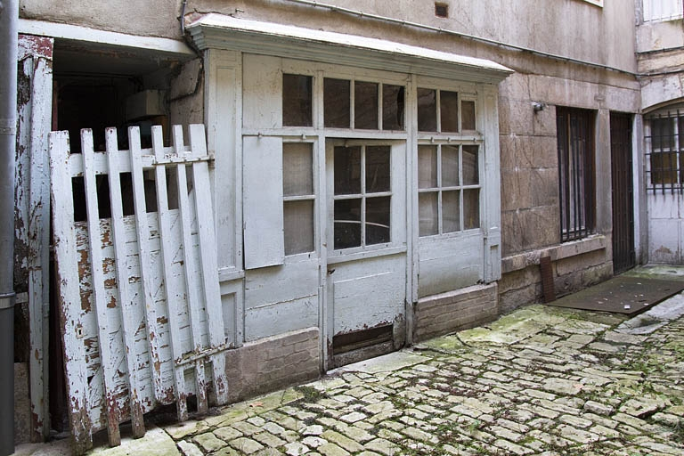 Aile droite sur cour : détail de la devanture en bois d'une ancienne boutique. © Yves Sancey / Région Bourgogne-Franche-Comté, Inventaire du patrimoine - 2012