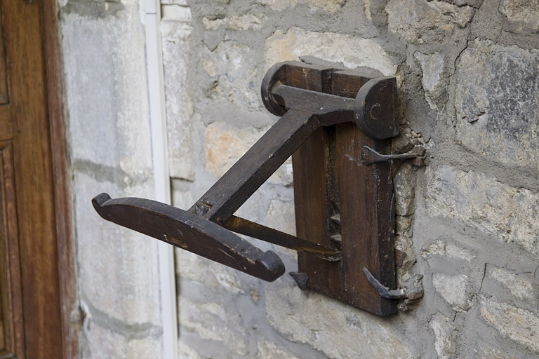 Logis principal, façade sur cour : détail d'un objet en bois non identifié (lutrin ?) situé à côté de la porte d'entrée de l'appartement du premier étage. © Yves Sancey / Région Bourgogne-Franche-Comté, Inventaire du patrimoine - 2012