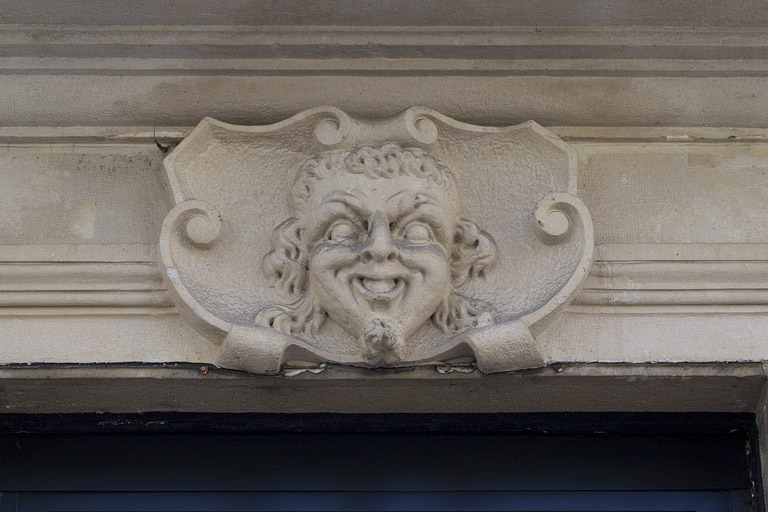 Façade antérieure, vue rapprochée d'un mascaron sur la porte d'entrée du magasin. © Yves Sancey / Région Bourgogne-Franche-Comté, Inventaire du patrimoine - 2012