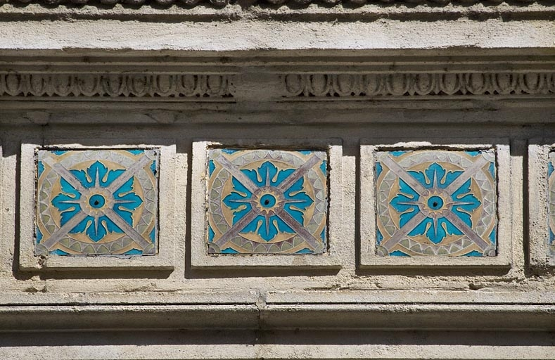 Façade antérieure : détail du décor en céramique au-dessus des fenêtres du premier étage, vue rapprochée. © Yves Sancey / Région Bourgogne-Franche-Comté, Inventaire du patrimoine - 2012