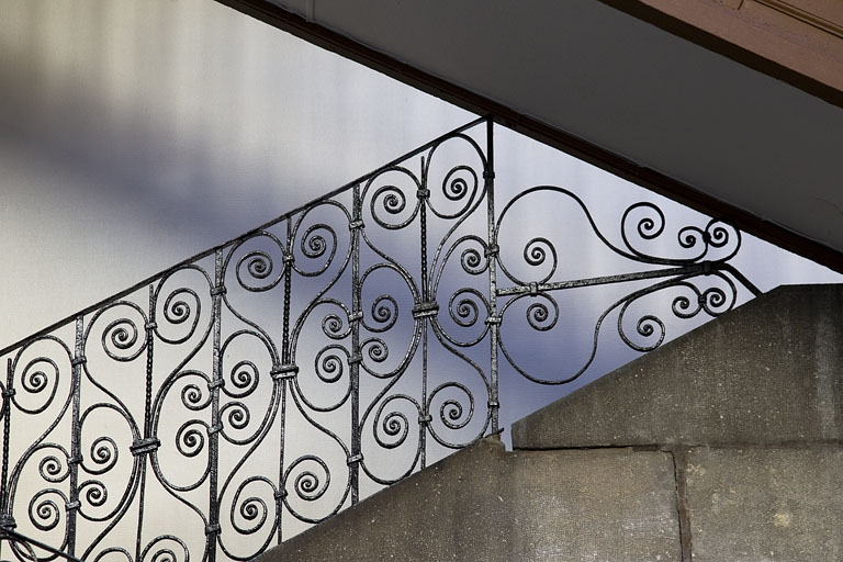 Escalier à cage ouverte à droite de la première cour : détail du décor de la rampe en ferronnerie. © Yves Sancey / Région Bourgogne-Franche-Comté, Inventaire du patrimoine - 2012