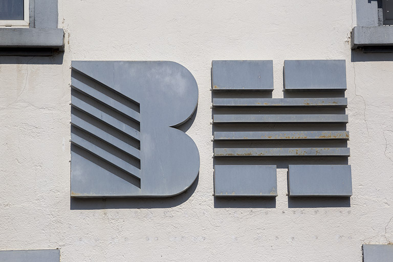 Usine, 1er corps de bâtiment : logotype de la société Bernard Haenni, sur la façade latérale gauche. © Yves Sancey / Région Bourgogne-Franche-Comté, Inventaire du patrimoine - 2012 Usine, 1er corps de bâtiment : logotype de la société Bernard Haenni, sur la façade latérale gauche. © Yves Sancey / Région Bourgogne-Franche-Comté, Inventaire du patrimoine - 2012