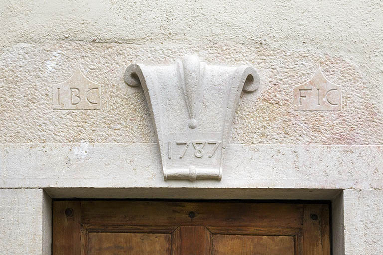 Façade antérieure : linteau orné et daté de la porte de gauche. © Yves Sancey / Région Bourgogne-Franche-Comté, Inventaire du patrimoine - 2013