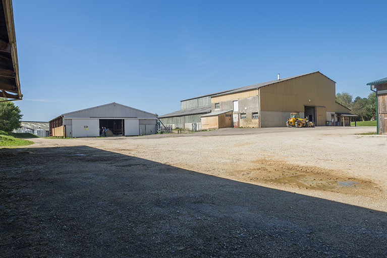 Cour formée par les trois hangars et l'angle sud-est du bâtiment d'exploitation d'élevage bovin et ovin.  © Mary Ruffinoni / Région Bourgogne-Franche-Comté, Inventaire du patrimoine - 2013