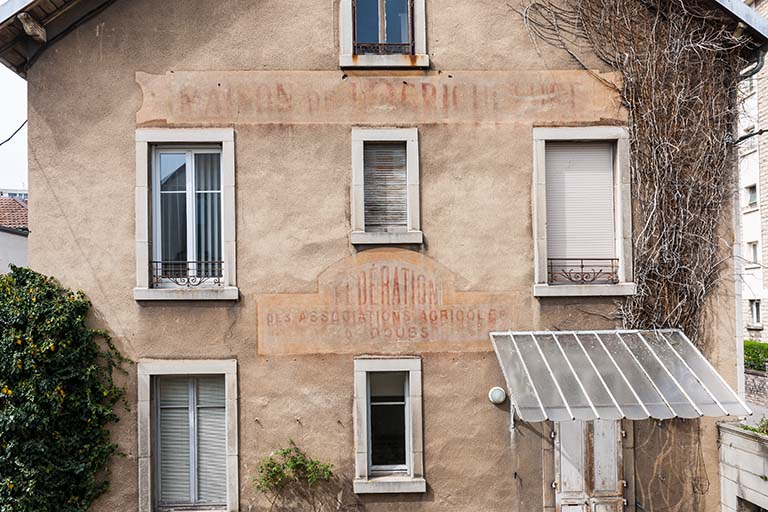 Bâtiment de l'administration : inscriptions sur la façade latérale gauche. © Jérôme Mongreville / Région Bourgogne-Franche-Comté, Inventaire du patrimoine - 2014 Bâtiment de l'administration : inscriptions sur la façade latérale gauche. © Jérôme Mongreville / Région Bourgogne-Franche-Comté, Inventaire du patrimoine - 2014