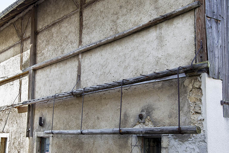 Ecurie : support pour stockage vertical de barres métalliques, sur la façade antérieure. © Sonia Dourlot / Région Bourgogne-Franche-Comté, Inventaire du patrimoine - 2014