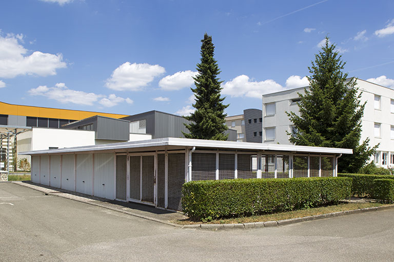 Vue d'ensemble depuis l'angle sud-ouest du local à vélo et garages. © Sonia Dourlot / Région Bourgogne-Franche-Comté, Inventaire du patrimoine - 2014