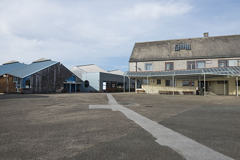 Cour, dite place des droits de l'homme, face à l'accueil au nord, façade est de l'atelier mécanique et son mur sud-est percé d'un oculus, face à l'externat. © Mary Ruffinoni / Région Bourgogne-Franche-Comté, Inventaire du patrimoine - 2014