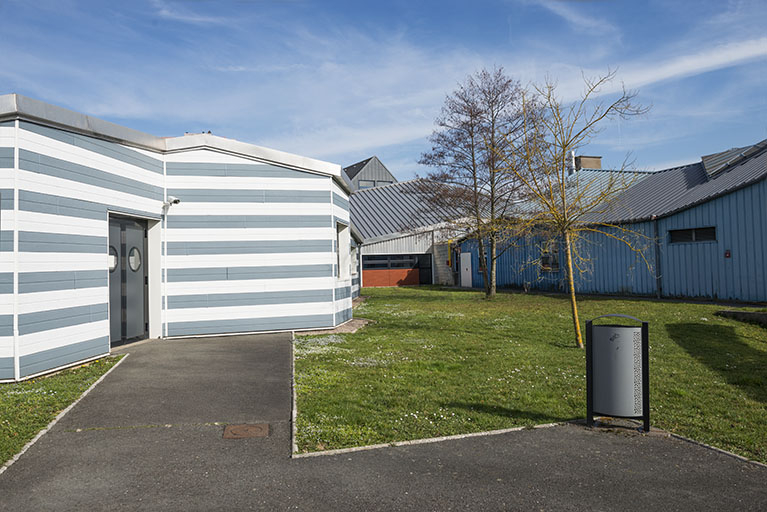 Cour engazonnée à l'ouest autour de laquelle sont disposés des ateliers de mécanique. © Mary Ruffinoni / Région Bourgogne-Franche-Comté, Inventaire du patrimoine - 2014
