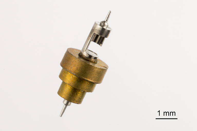 Echappement à cylindre : cylindre (en métal blanc) équipé de la "siette" (assise du balancier) en laiton. © Sonia Dourlot / Région Bourgogne-Franche-Comté, Inventaire du patrimoine - 2015