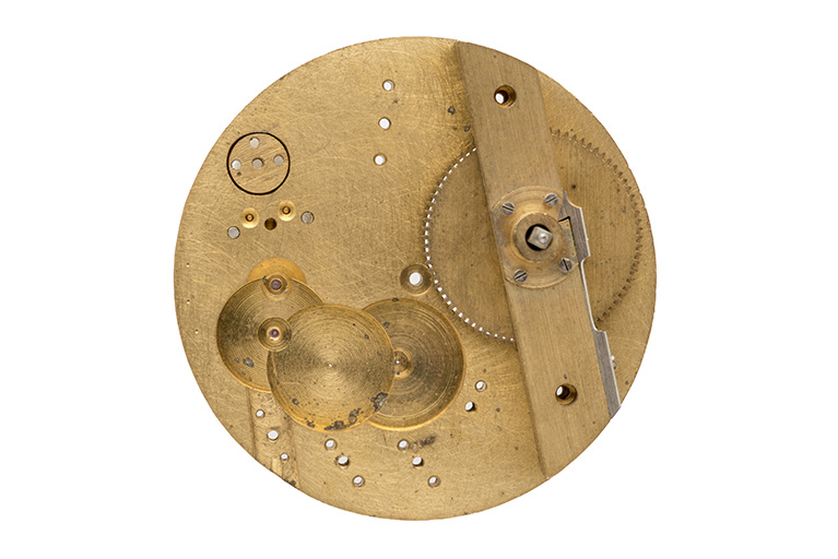 Platine nue, vue du côté pont. Noter le chariot à gauche, les creusures en bas, les trous pour les mobiles, le barillet et son pont à droite. © Sonia Dourlot / Région Bourgogne-Franche-Comté, Inventaire du patrimoine - 2015