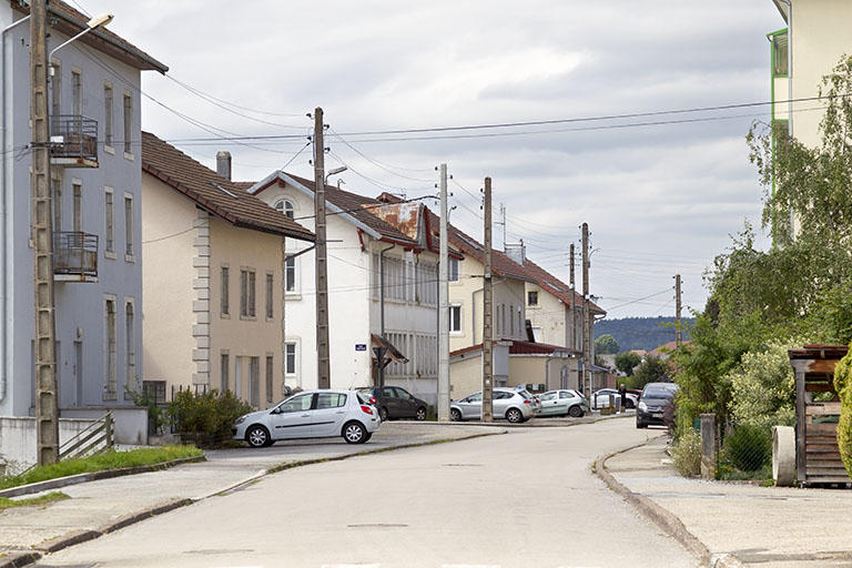 Vue d'ensemble de la rue de la Gare. Les trois bâtiments au centre sont, de gauche à droite, le comptoir d'horlogerie Demangelle (n° 11), l'usine de boîtes de montre puis de décolletage et d'emboutissage Pagès (n° 13), et l'atelier de mécanique Prét… © Sonia Dourlot / Région Bourgogne-Franche-Comté, Inventaire du patrimoine - 2015 Vue d'ensemble de la rue de la Gare. Les trois bâtiments au centre sont, de gauche à droite, le comptoir d'horlogerie Demangelle (n° 11), l'usine de boîtes de montre puis de décolletage et d'emboutissage Pagès (n° 13), et l'atelier de mécanique Prét… © Sonia Dourlot / Région Bourgogne-Franche-Comté, Inventaire du patrimoine - 2015