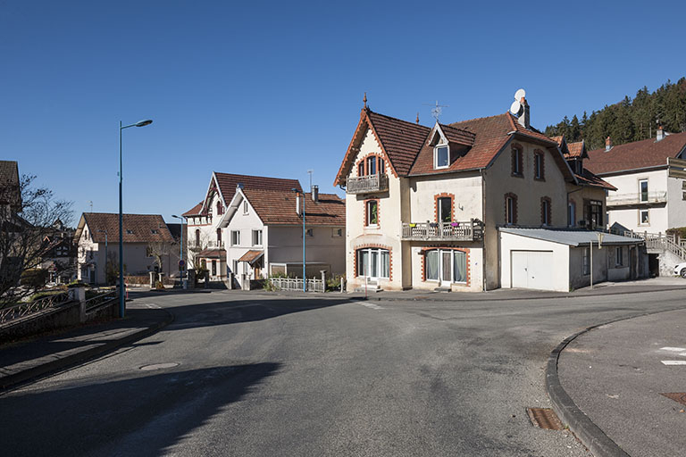 La rue du Mont-Miroir, à son carrefour avec la rue de Goule. De droite à gauche : maison et café Grux puis atelier de l'horloger Amédée Mairot (au n° 29), usine d'assortiments à cylindre de Paul et Robert Mauvais (au n° 27) et villa de l'architecte … © Jérôme Mongreville / Région Bourgogne-Franche-Comté, Inventaire du patrimoine - 2015