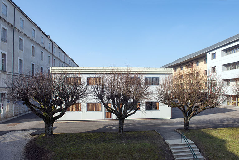 Cour et façade postérieure sud-est des salles de cours en préfabriqué, vues depuis le bâtiment de cantine internat de filles © Mary Ruffinoni / Région Bourgogne-Franche-Comté, Inventaire du patrimoine - 2015