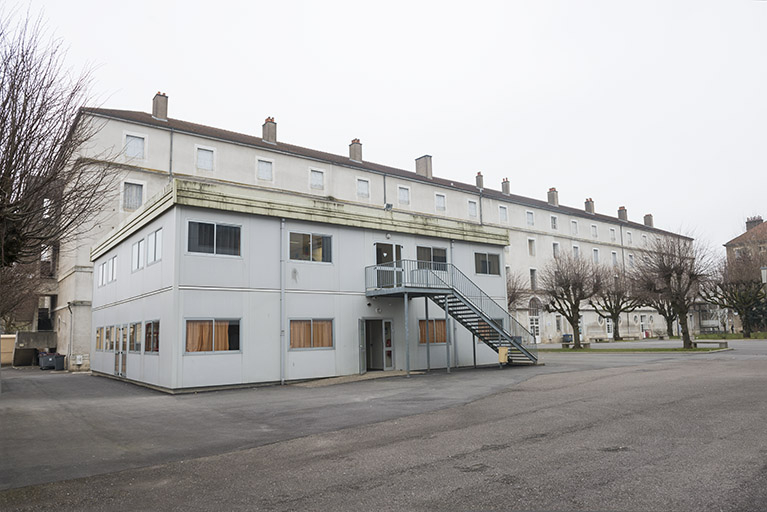 Angle sud-est, façade nord-est du préfabriqué dans la cour, façade nord-est de l'ancienne caserne. © Mary Ruffinoni / Région Bourgogne-Franche-Comté, Inventaire du patrimoine - 2015